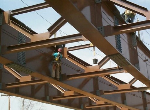 Men standing on bridge beams